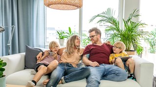 Far, mor og to børn i sofaen