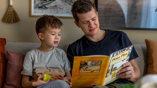 Far og søn læser en bog