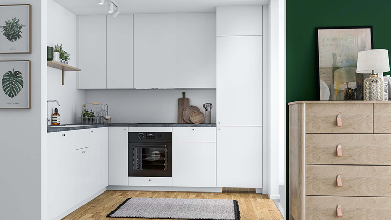Lyst køkken med mørk bordplade og hylde med planter på væggen